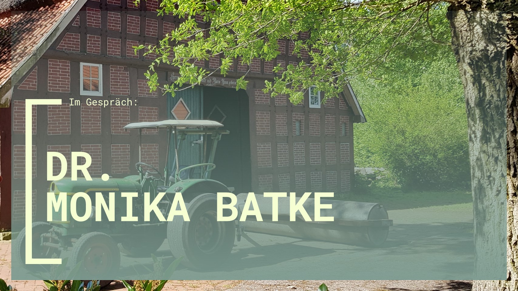Schriftzug "Im Gespräch: Dr. Monika Batke" im Vordergrund. Im Hintergrund ist ein Traktor vor einer roten Scheune zu sehen.